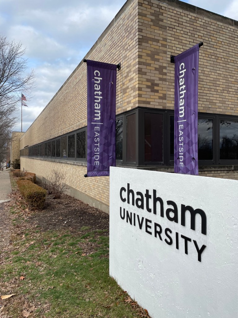 a yellow brick building with purple banners
